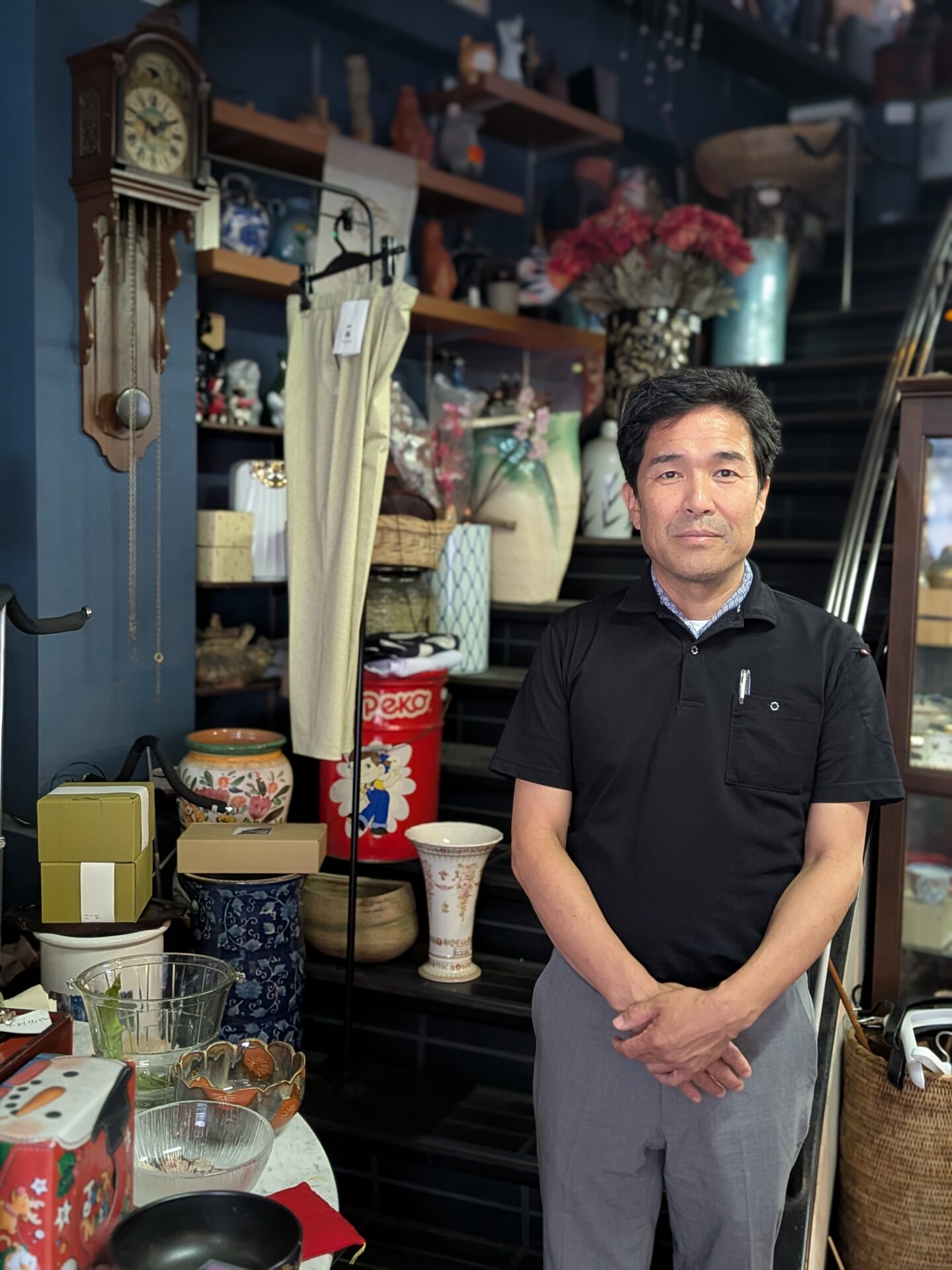 独歩堂の店内で器に囲まれて立つ藤野真二