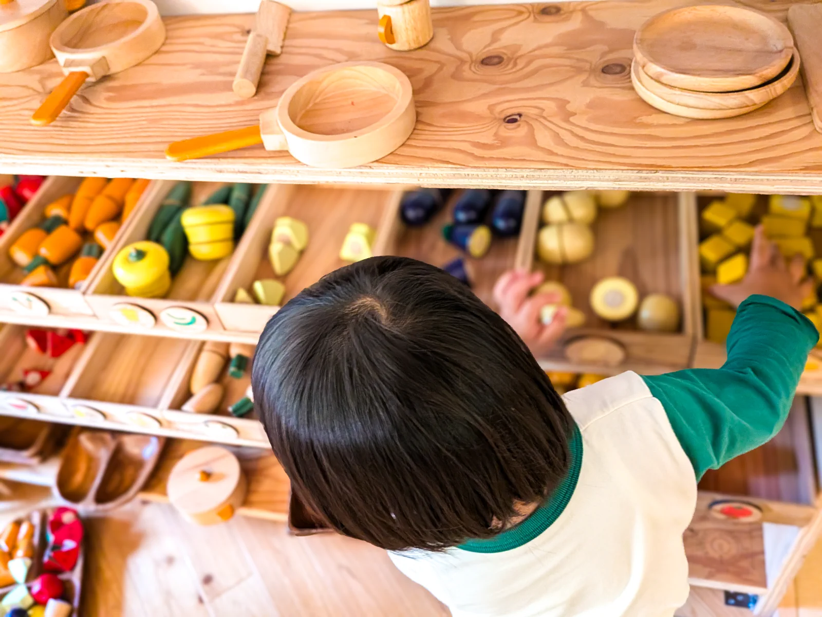 木の食材を選びながら、さかわマルシェで遊ぶ子ども